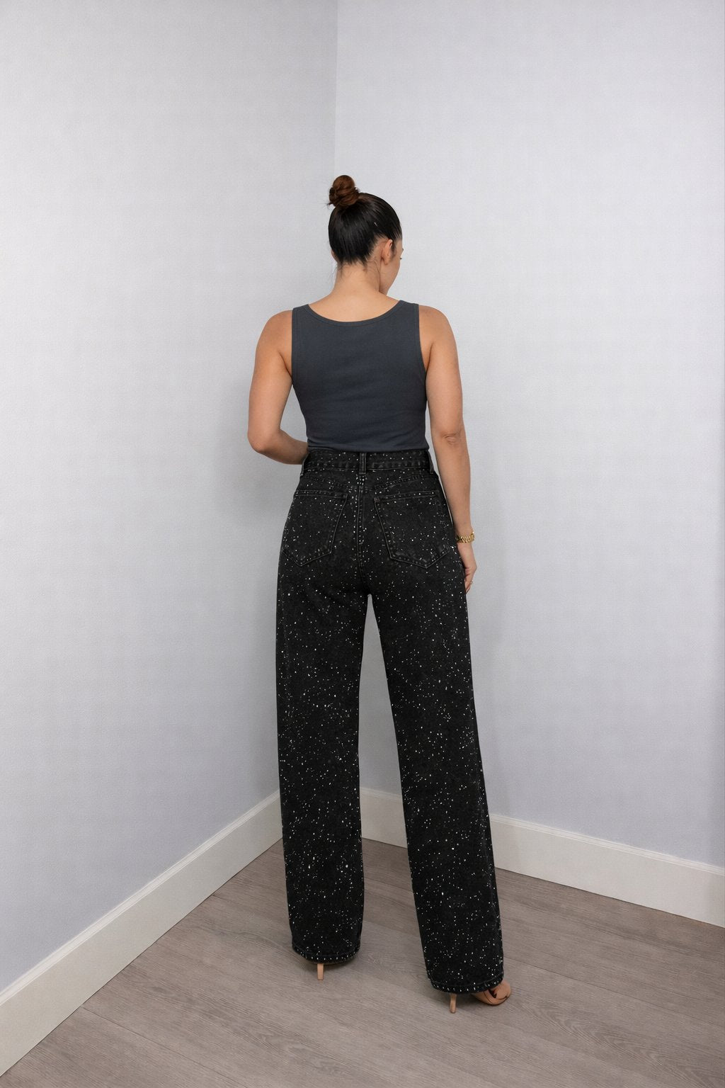 Full lengde bilde av dame i glitrende jeans med høy midje og rette ben, moteriktig.