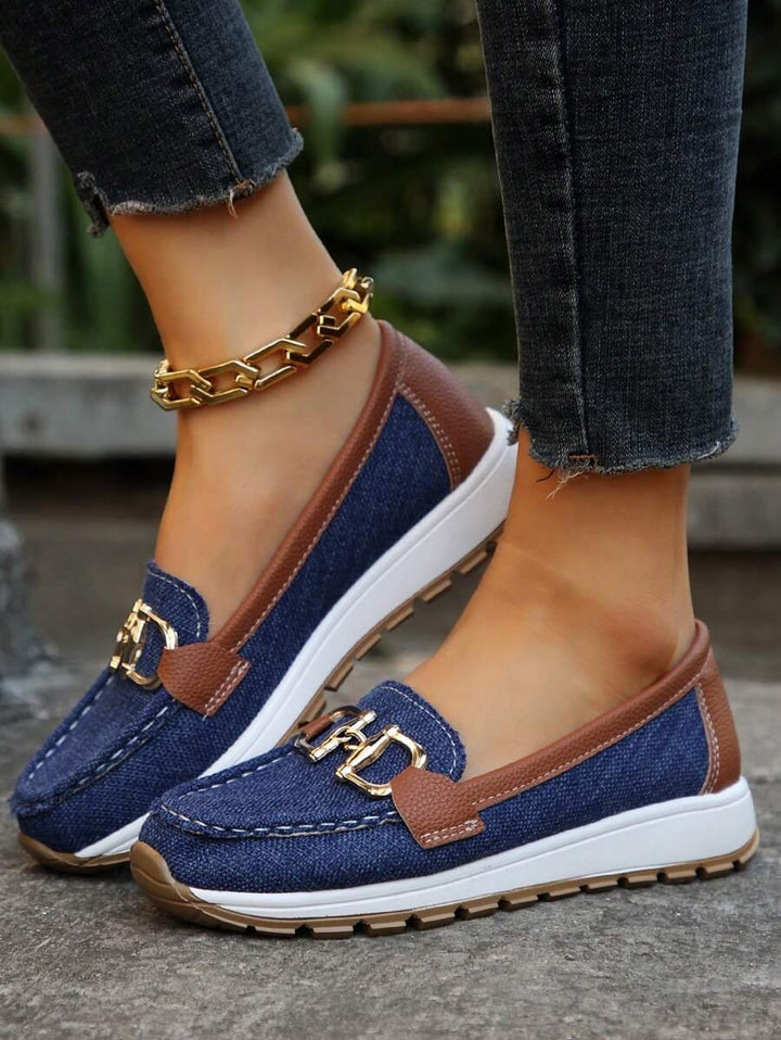Brun ortopedisk slip-on damesko, flate loafers med gullspenne og sklisikker såle for kvinnekomfort.