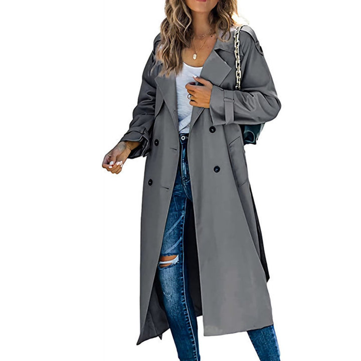 Kvinne iført oversized dobbeltradet trench coat med belte, gående. Komfortabel høstjakke.