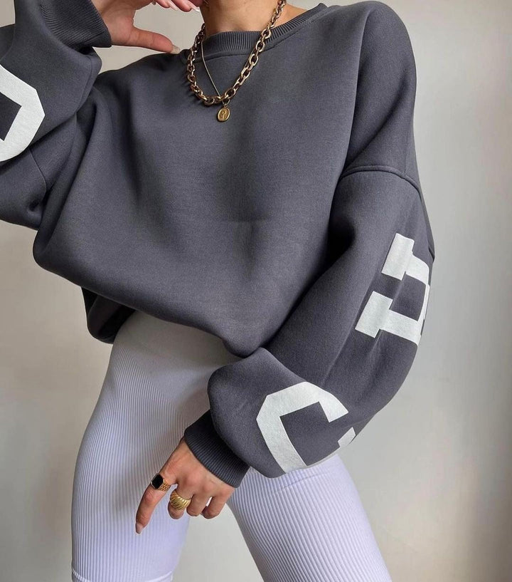 Komfortabel oversized varsity-genser for dame, med stilig grafisk trykk, ideell til hverdag.
