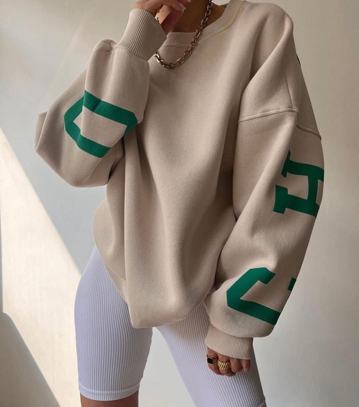 Damegenser med trendy trykk og oversized passform, en varsitygenser for streetwear.