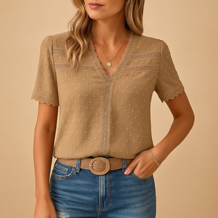 Elegant kvinnebluse med V-hals, korte ermer og delikate blonde detaljer for en komfortabel sommerstil.