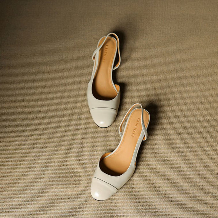 Klassiske svarte slingback pumps i patentlakk, med skinnende overflate og elegant mandeltå.