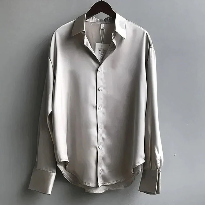 Mote kvinneskjorte i myk satin med elegant spiss krage. En allsidig langermet bluse for kvinner.
