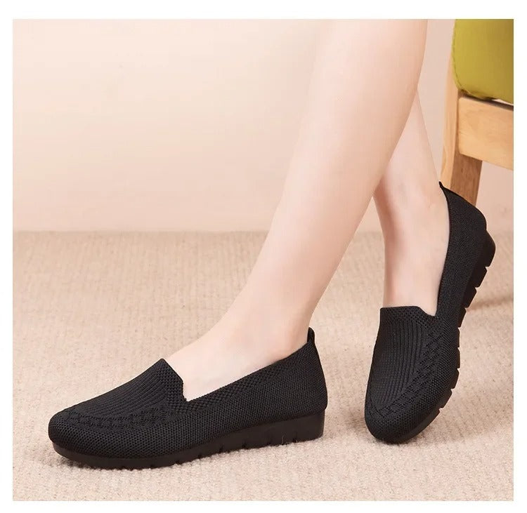 Kvinne iført grå pustende slip-on loafers, ideell for en avslappet og komfortabel sommerstil.