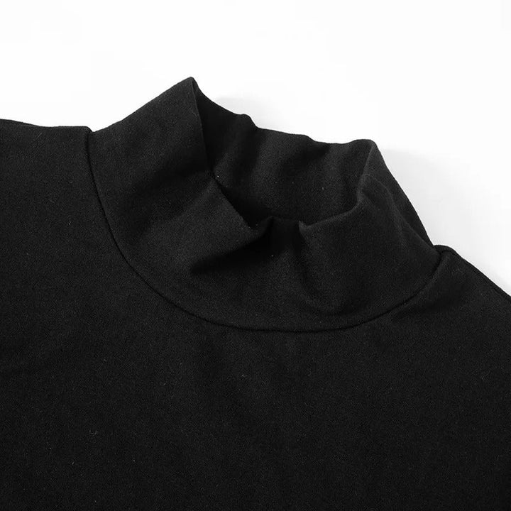 Dame iført elegant svart/hvit patchwork bodycon kjole med høy hals. Perfekt festkjole.