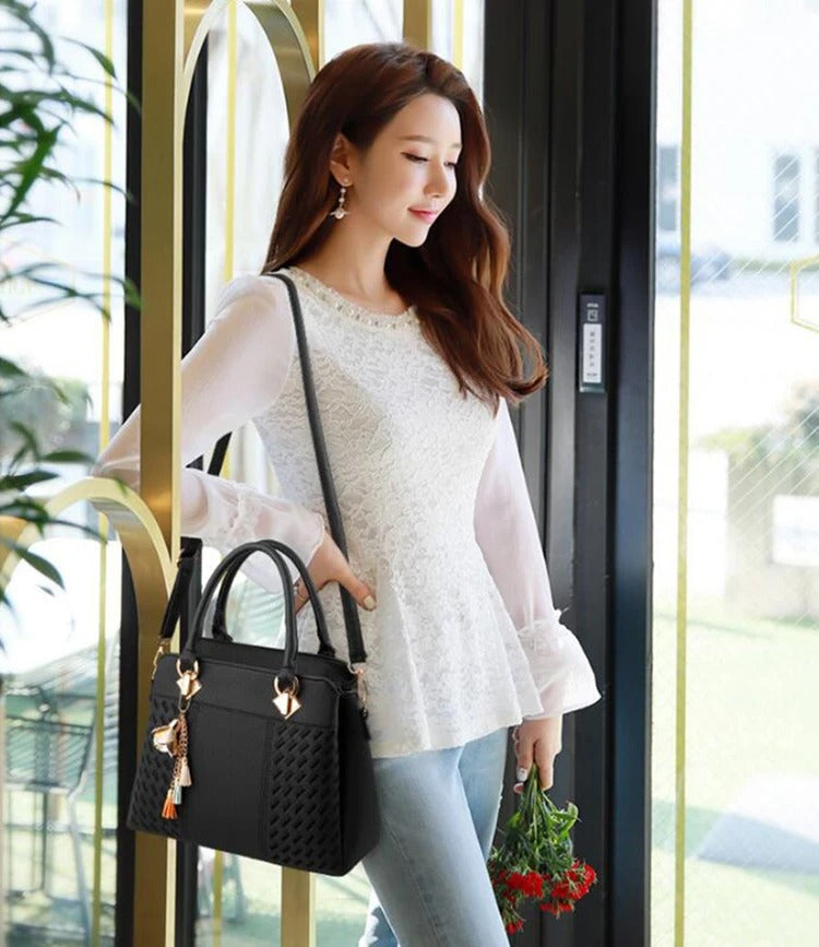 Svart elegant crossbody-veske for kvinner, med broderte detaljer og en sofistikert dusk.