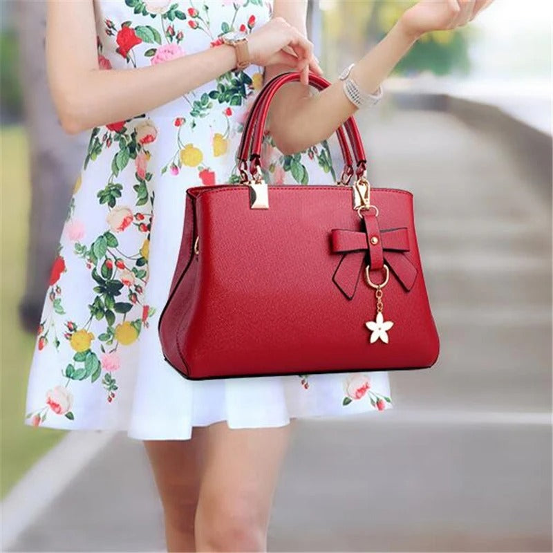 Dame crossbody-veske med justerbar stropp og elegant blomstersjarme. En praktisk skulderveske.
