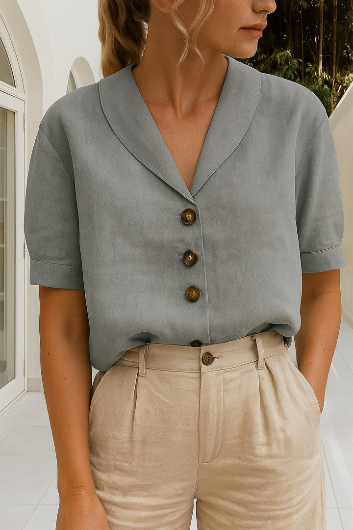 Motebevisst damebluse med elegant innviket V-hals og korte ermer. Allsidig for både hverdag og festantrekk.