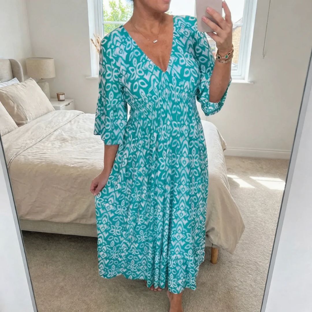 Luftig polyester maxikjole med A-linje snitt, V-hals og elegant trykk. En lett sommerkjole.