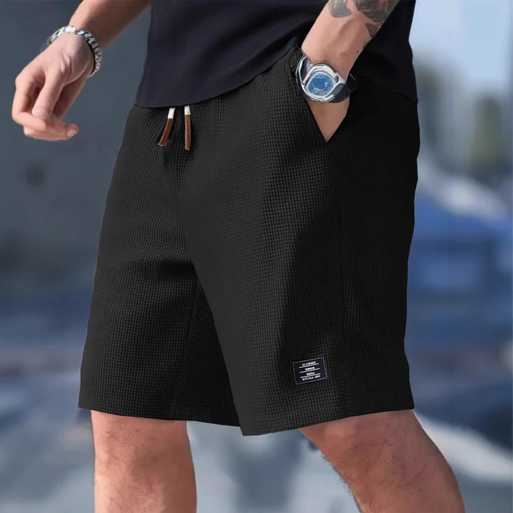 Mørkeblå treningsshorts for menn med god passform, pustende stoff og sidelommer. Ideell for sport.