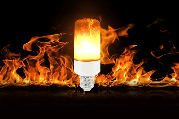 Nærbilde av LED-pære med levende flammeeffekt, lyser opp mørket med varm glød.