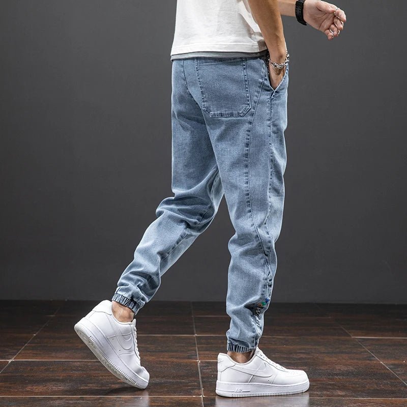 Komfortable menns joggebukser i stretch denim, viser fleksibelt stoff og elastisk midje.