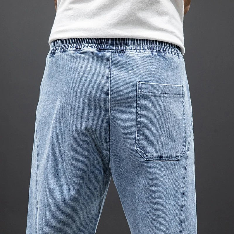 Nærbilde av herres stretch denim joggebukser, fremhever den myke teksturen og stretch-egenskapene.