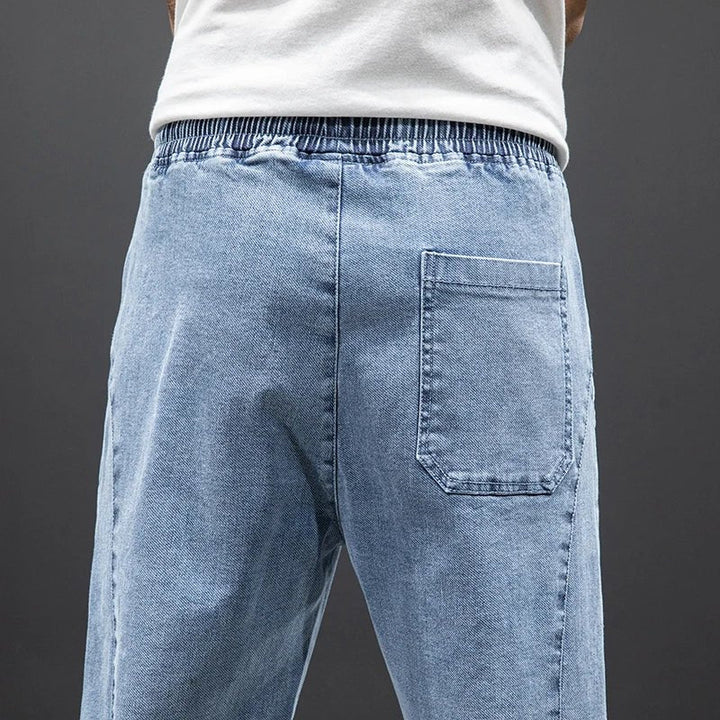 Nærbilde av herres stretch denim joggebukser, fremhever den myke teksturen og stretch-egenskapene.