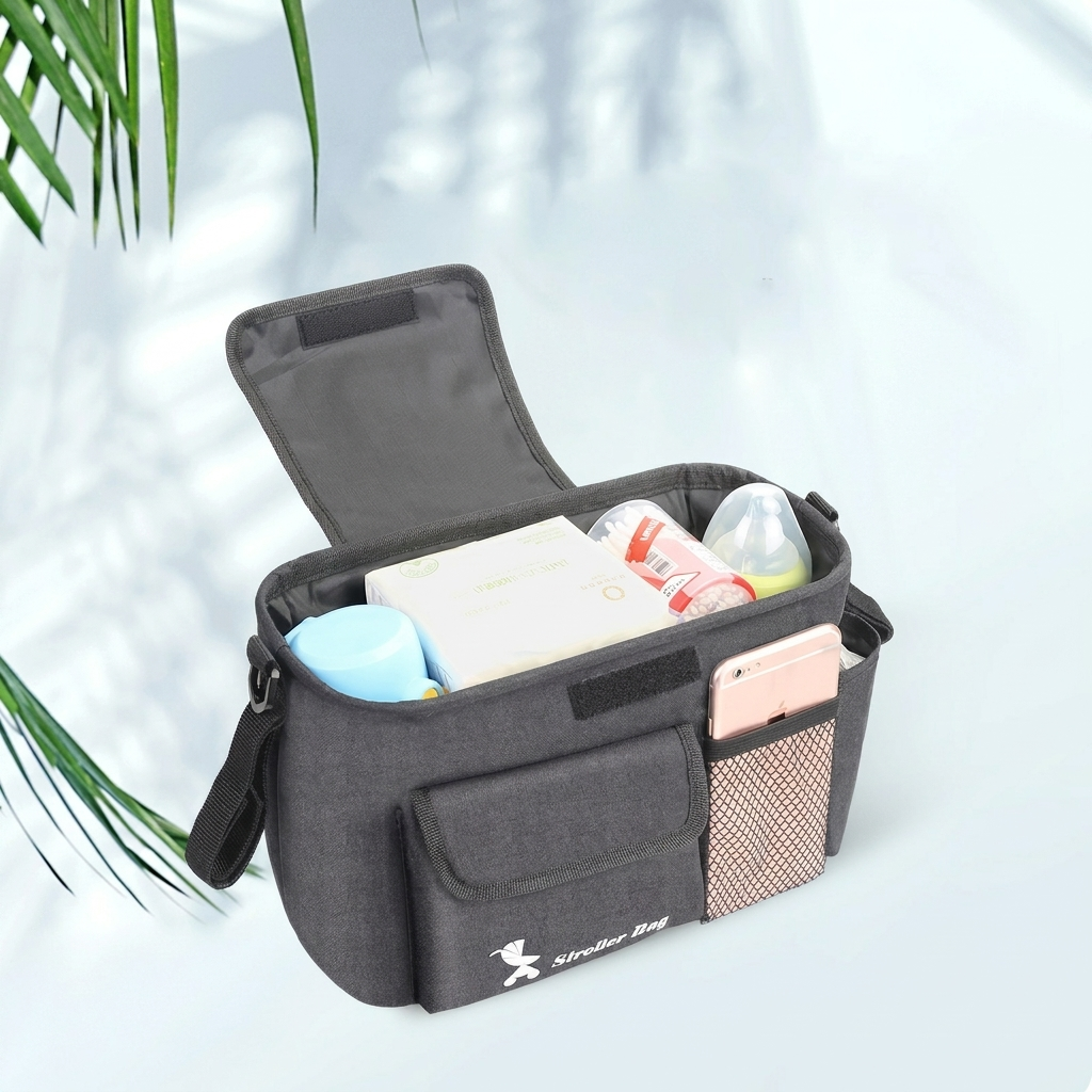 Nærbilde av en svart, robust vognbag med ulike lommer, perfekt for barnevogn oppbevaring.