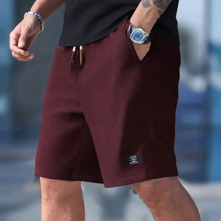 Menns sportsshorts med snøring, løs passform og lommer. Perfekt for trening, hverdag og sportsklær.