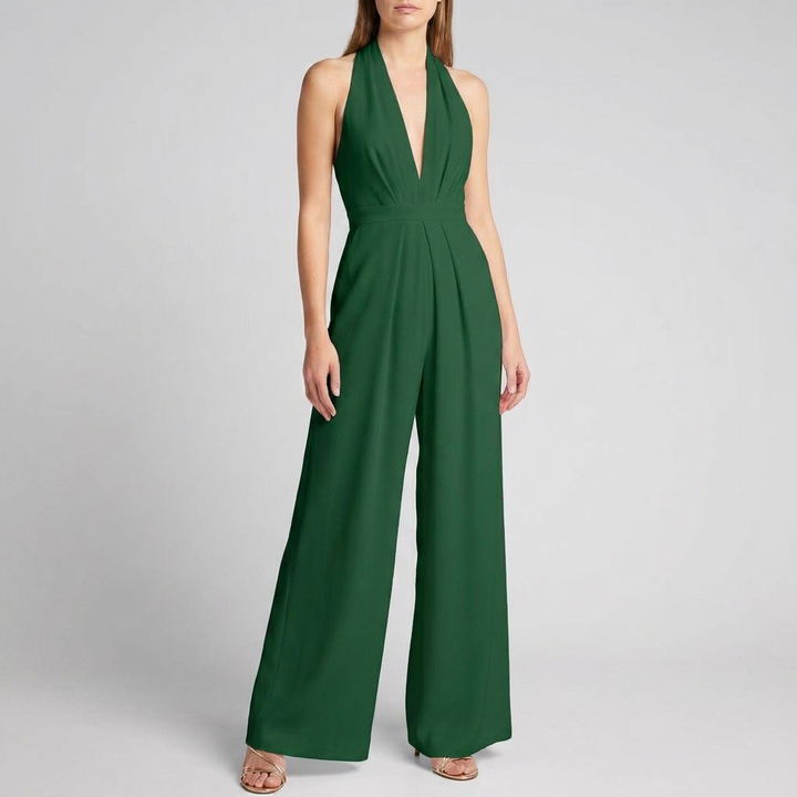 Motebevisst kvinne i ryggløs halterneck jumpsuit med brede ben, et chic valg for enhver garderobe.