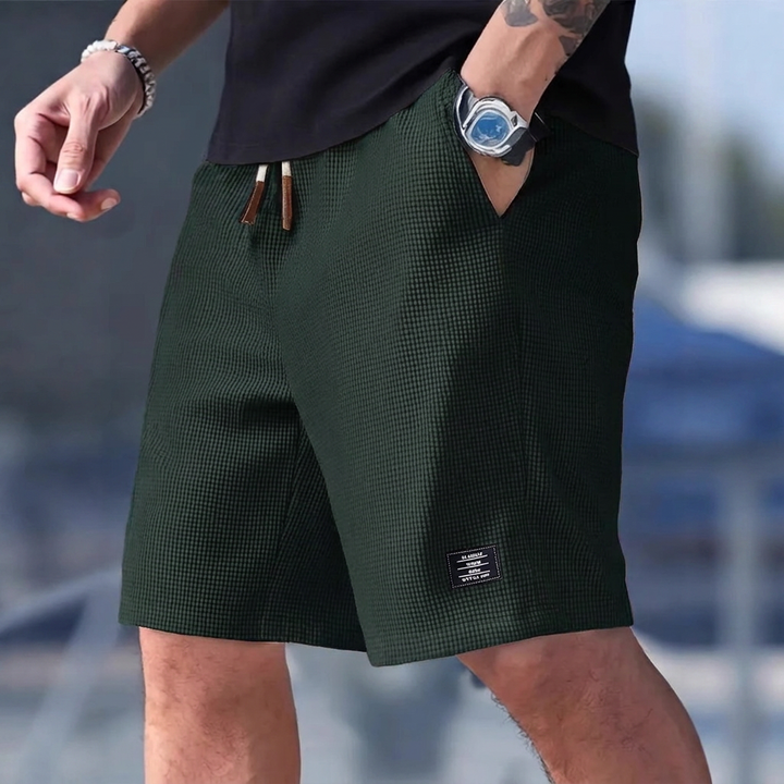 Stilig casualshorts i marineblå, med lommer og løs passform. Perfekt sommershorts for herrer.