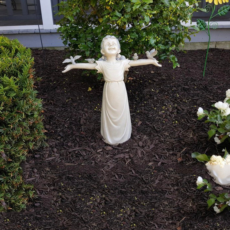 Nærbilde av en yndig jentestatue, en sjarmerende hagepynt som tilfører detaljer til uteområdet.