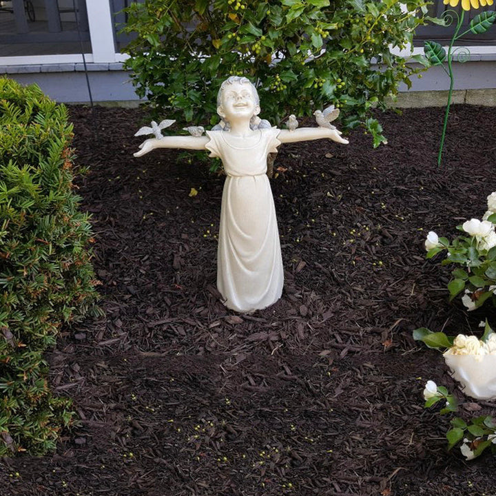 Nærbilde av en yndig jentestatue, en sjarmerende hagepynt som tilfører detaljer til uteområdet.
