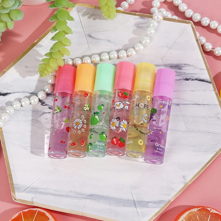 Hånd holder Kvinner Speil Vann Lipgloss Sett. 6 fruktige, fuktighetsgivende farger for lepper.