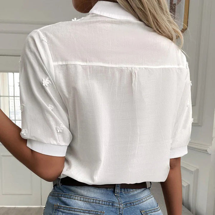 Stilren hvit dame sommerbluse med elegant, løs passform. Perfekt hverdagstopp som passer til alt.