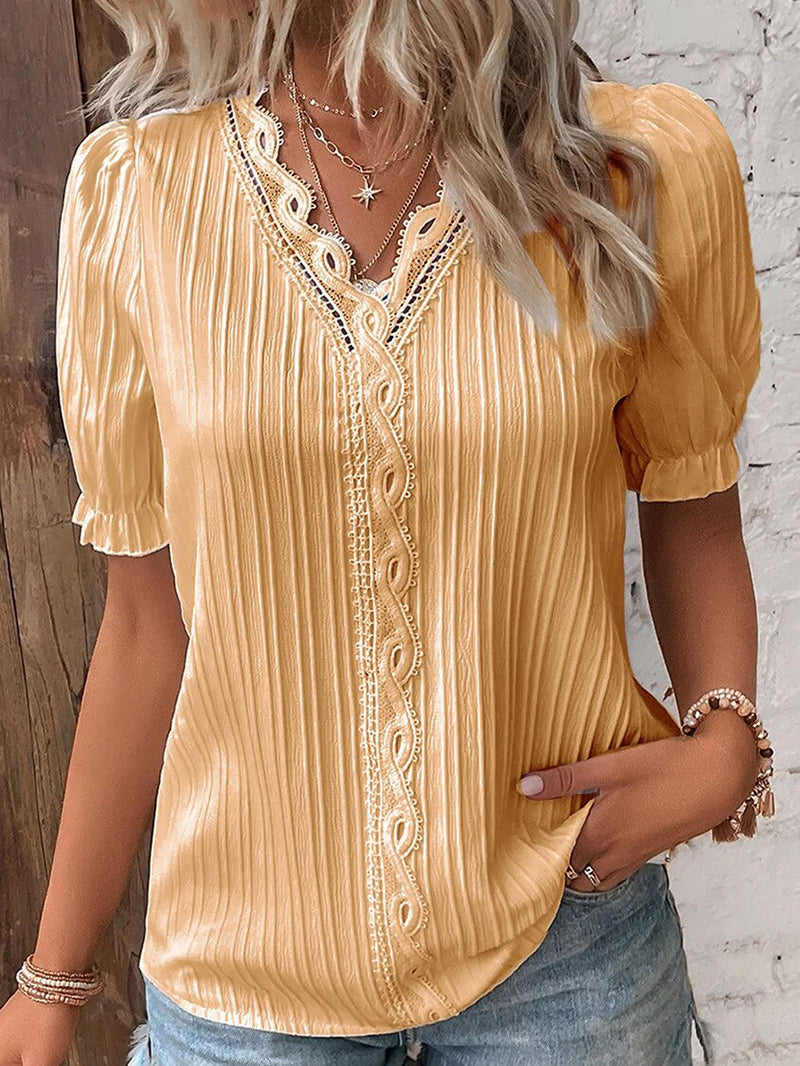 Elegant damebluse med dyp V-hals, voluminøse puffermer og feminine blondedetaljer. Komfortabel passform.