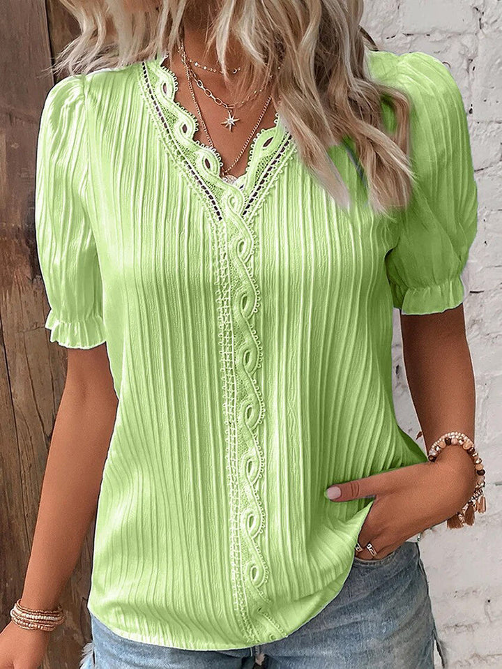 Stilren dame sommertopp med V-hals og puffermer. En elegant og komfortabel damebluse perfekt for fest.
