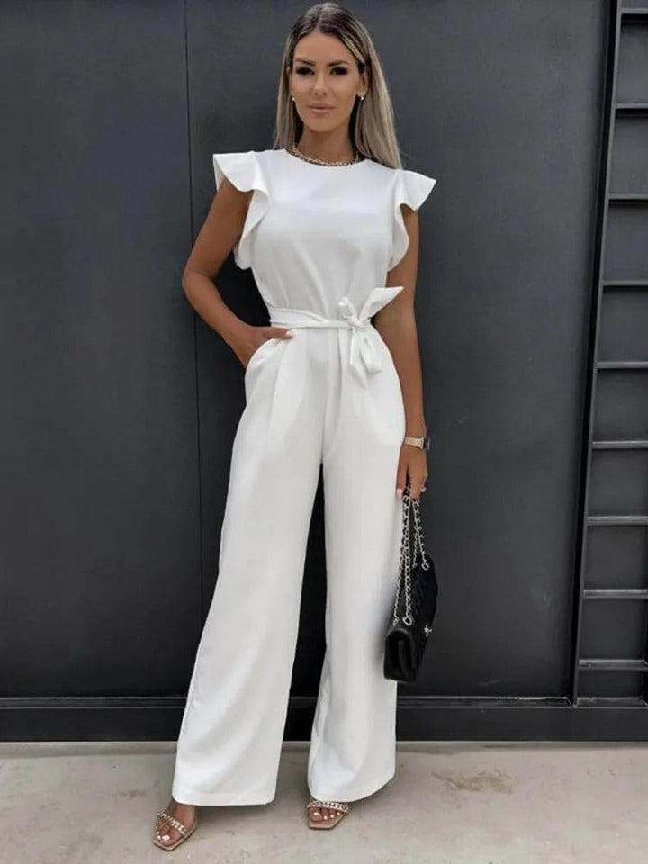 Nærbilde av volangermer på stilren damejumpsuit. Elegant detalj som skiller seg ut.