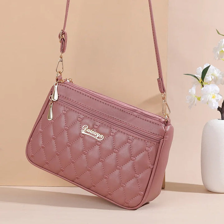 Detaljert nærbilde av broderiet på den praktiske crossbody-vesken i PU skinn for damer.