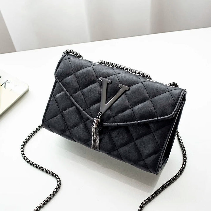Elegant hvit vattert skulderveske for dame med dusker. Perfekt crossbody veske for enhver anledning.