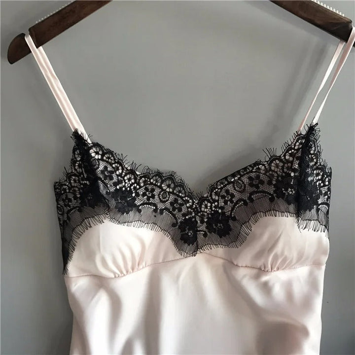Kvinne i luksuriøst sateng nattøysett med V-hals og shorts, perfekt for loungewear og avslapning.