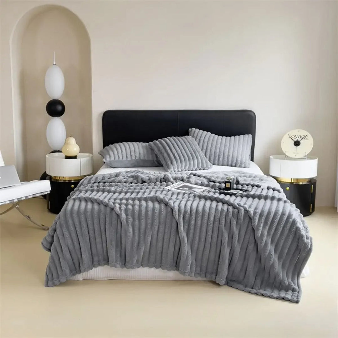 Interiørbilde med et elegant stripepledd med tykke striper, som gir varme og stil til rommet.