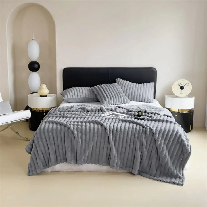 Interiørbilde med et elegant stripepledd med tykke striper, som gir varme og stil til rommet.