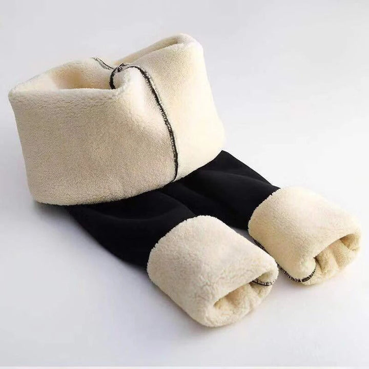 Kvinne i varme og komfortable leggings med høy midje, perfekt for koselige vinterdager hjemme.