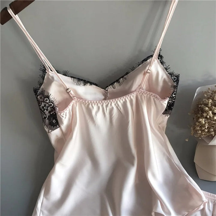 Elegant positur i luksuriøst sateng nattøysett for kvinner med V-hals og shorts. Stilige pyjamas.