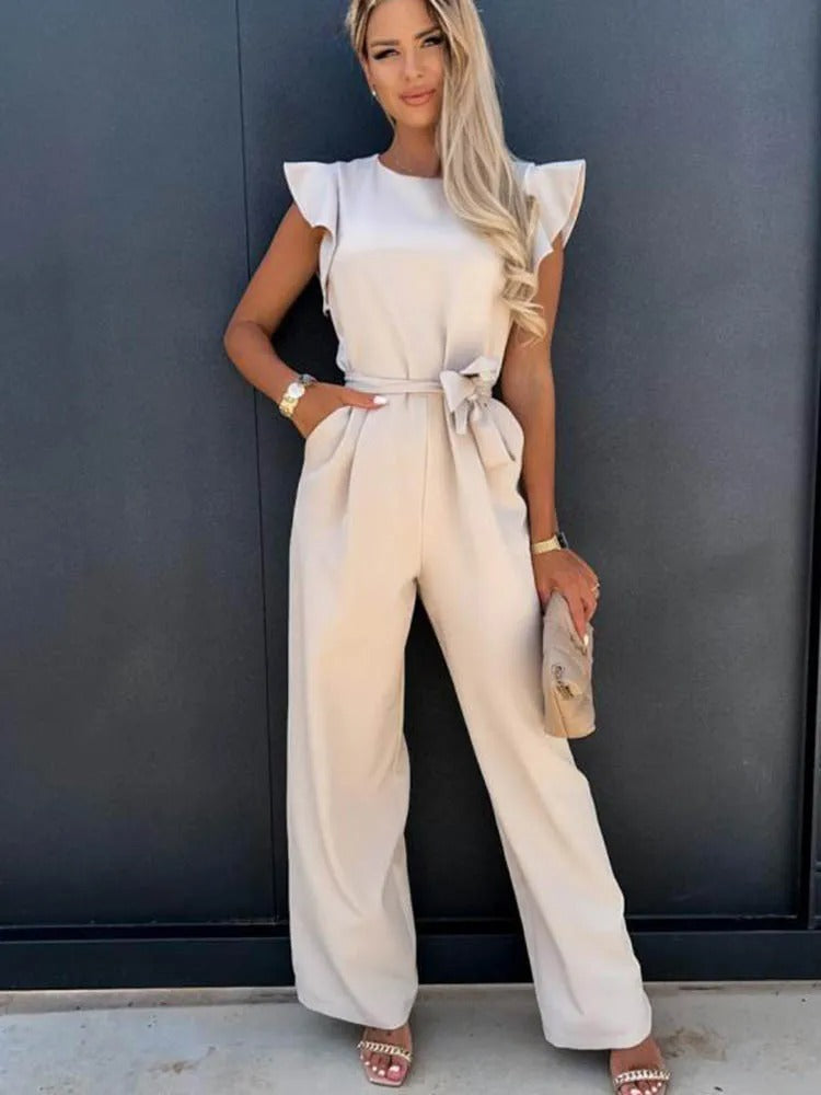 Hele kroppen bilde av dame i jumpsuit med volangermer og belte, viser elegant stil.