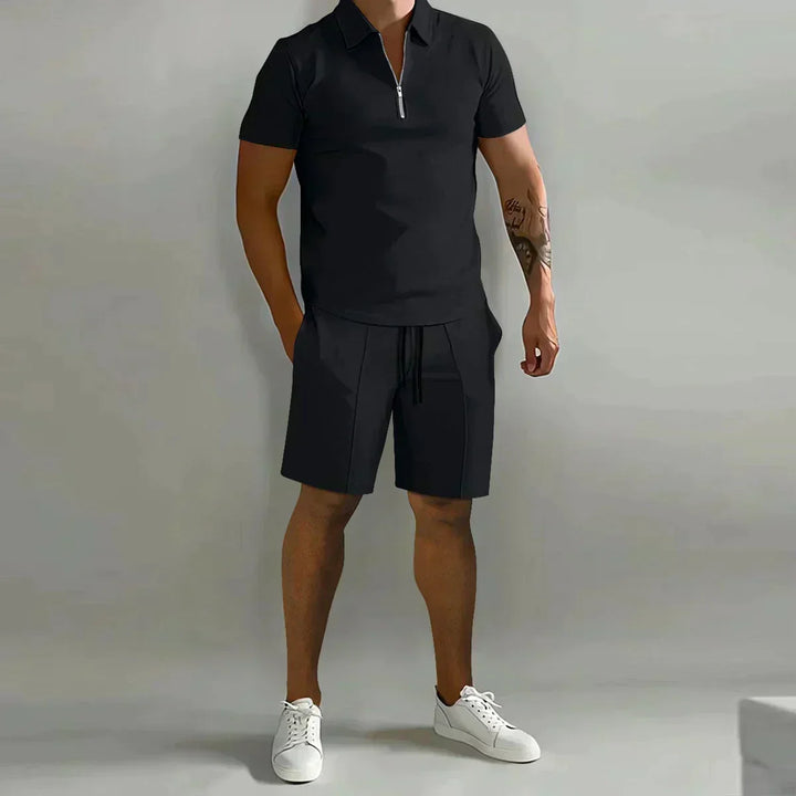 Elegant herre sommersett i marineblått, bestående av glidelåspolo og matchende shorts.