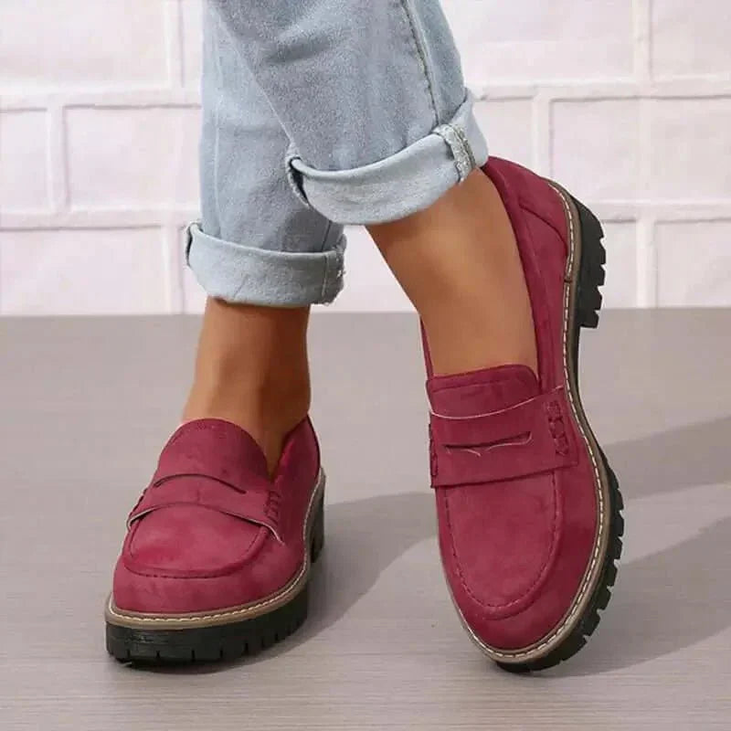 Stilige svarte loafers med tykk såle, en elegant slip-on flat for moderne kvinner.