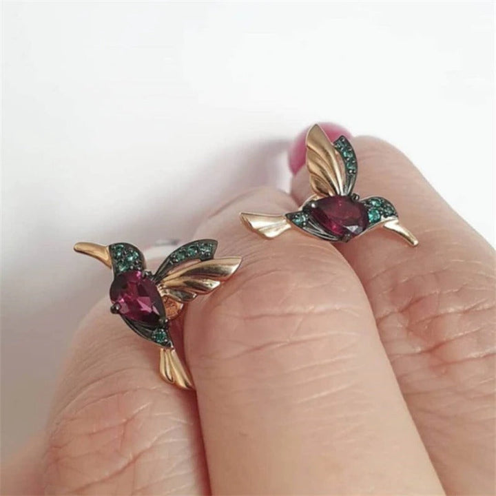 Kvinnelige kolibri øredobber med glitrende dråper, et elegant tilbehør med fargerike krystaller.