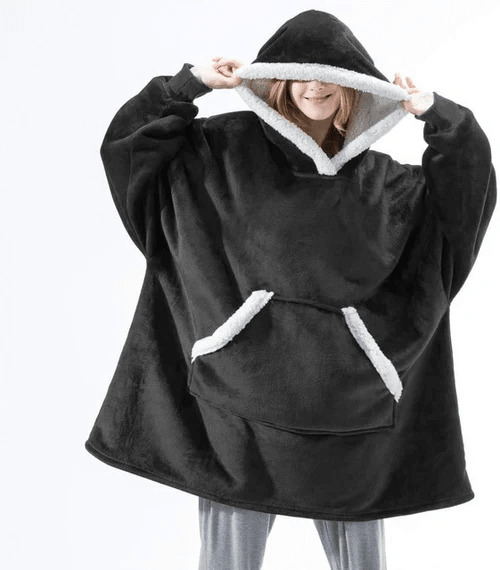 Person slapper av i et stort, koselig hoodie-teppe; perfekt for avslapning og hjemmekos.