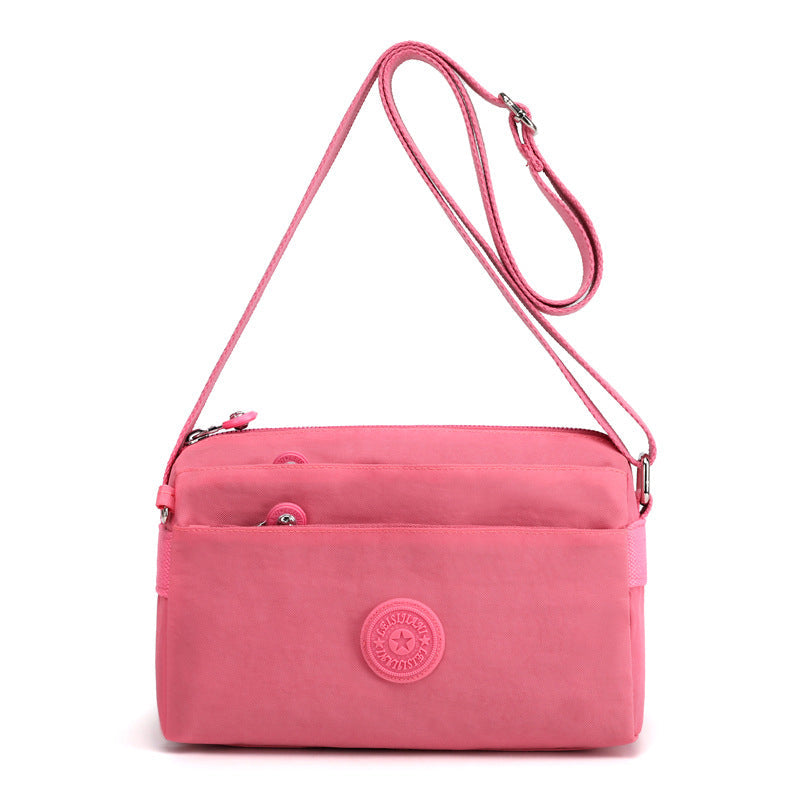 Nylon flerlags messenger bag med glidelås. Romslig dameveske som er både praktisk og stilfull.