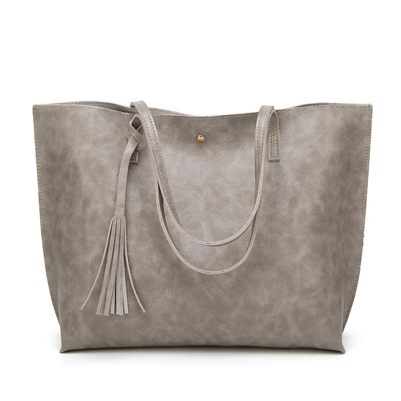 Elegant rød skulderveske med dusk. Trendy messenger bag i PU-lær. Romslig for hverdagsbruk.