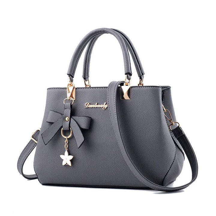 Klassisk dame crossbody-veske med blomsterdetalj, ideell til hverdags og som mote-tilbehør.