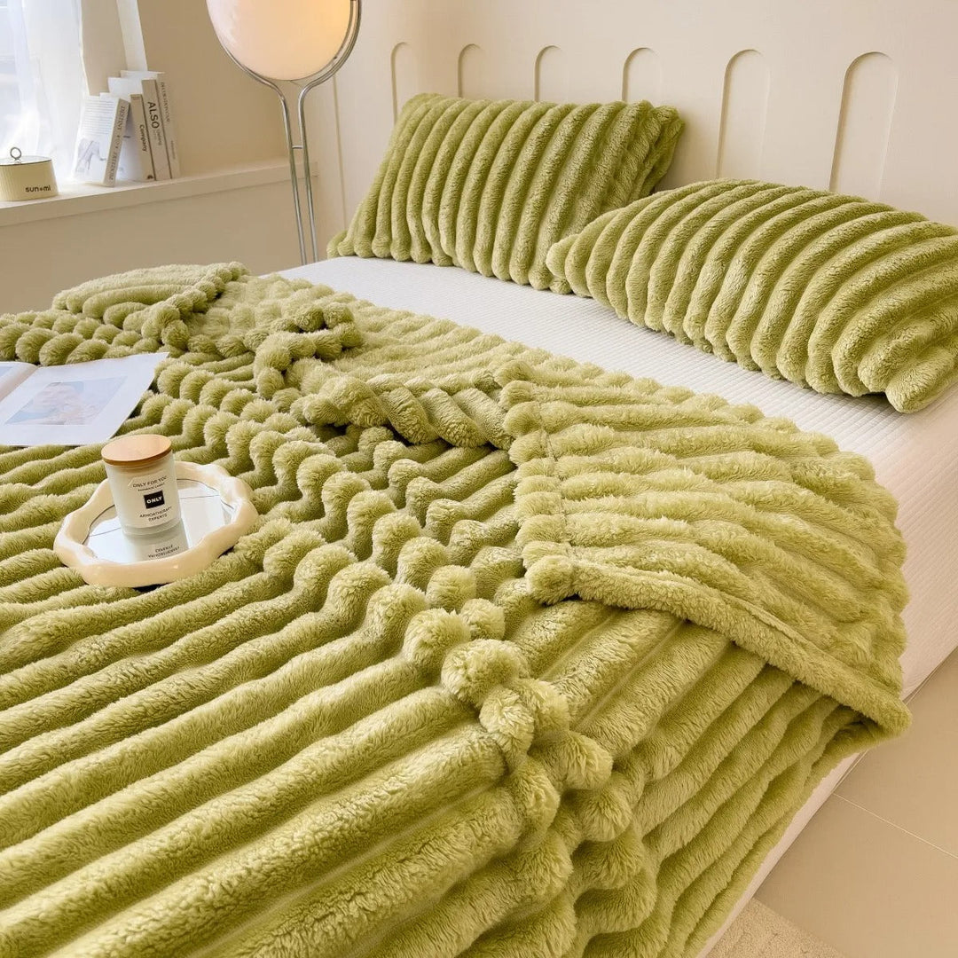 Sammenbrettet stripepledd, klart til bruk som et koselig sofateppe eller interiørdetalj i hjemmet.