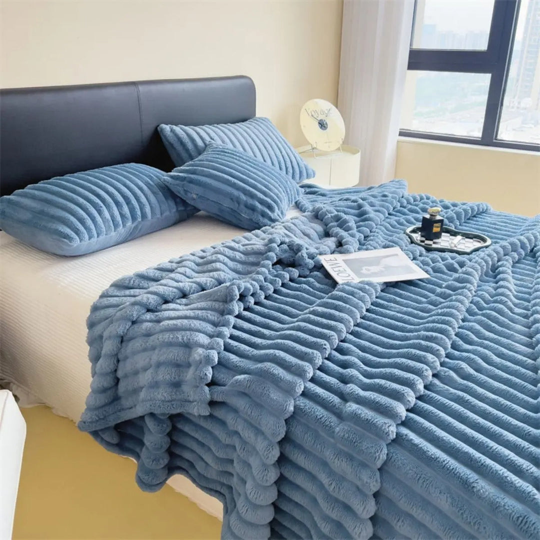 Elegant multifunksjonelt pledd med tykke striper, drapert over en sofa. Gir varme og stil til stuen.