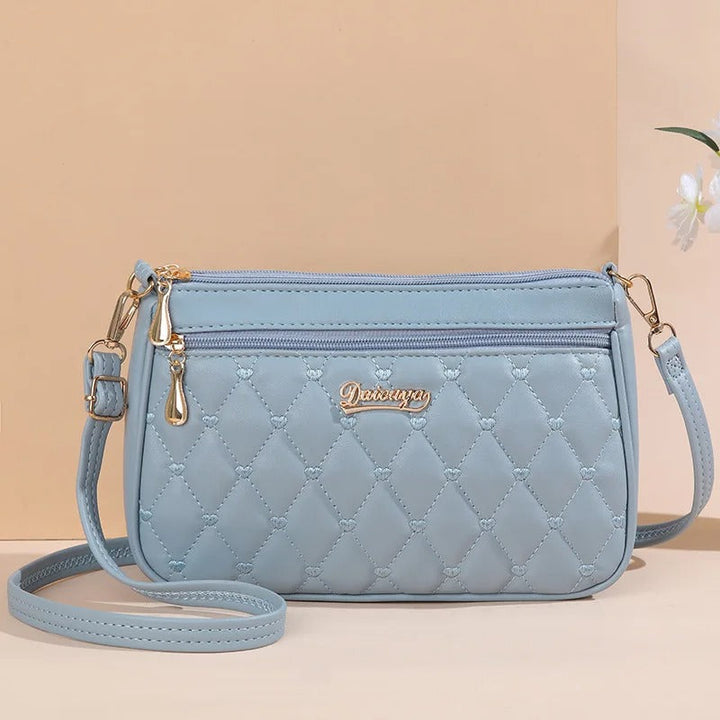 Hvit brodert crossbody veske i PU skinn, lett og komfortabel for langvarig bruk.