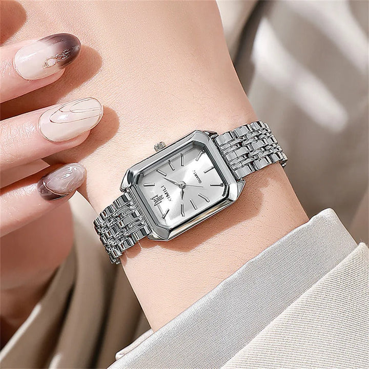 Firkantet dameklokke i gull og sølv på kvinnehåndledd. Luksuriøst armbåndsur for en elegant stil.
