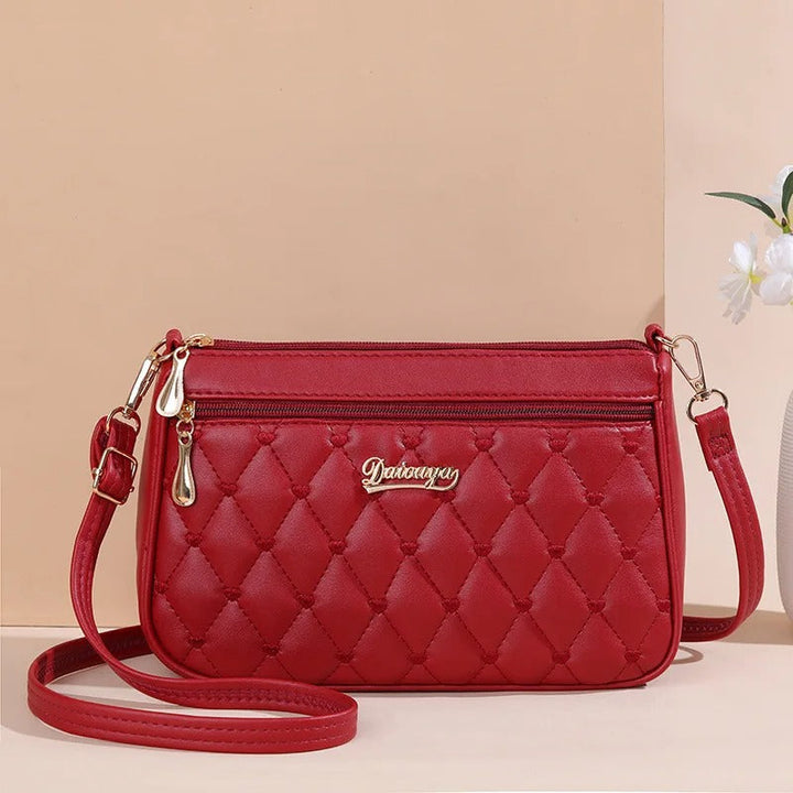 Innside av den praktiske crossbody-vesken: Fôret interiør med sikker glidelåslomme.